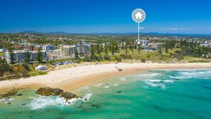 Un complejo turístico en la costa con alojamiento frente a la playa, aguas cristalinas y vistas del paisaje circundante.