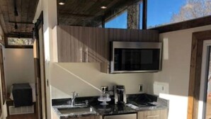 Een moderne keuken met roestvrijstalen apparatuur, houten kasten en een groot raam dat voor natuurlijk licht zorgt.