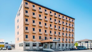 A multi-story hotel with a uniform facade, numerous balconies, and a clear sky. - Comfort Inn Kashima (Kamisu)