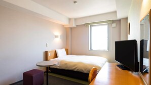 A hotel room with a bed, a small table, a TV, and a window. - Comfort Inn Kashima (Kamisu)
