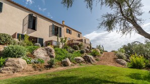 A two-story house with a sloped roof, large windows, and a stone facade.