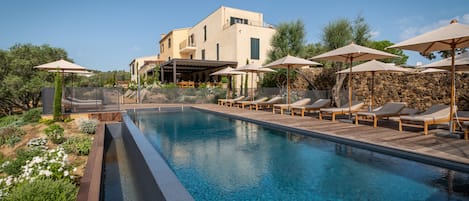Una piscina al aire libre de temporada, sombrillas