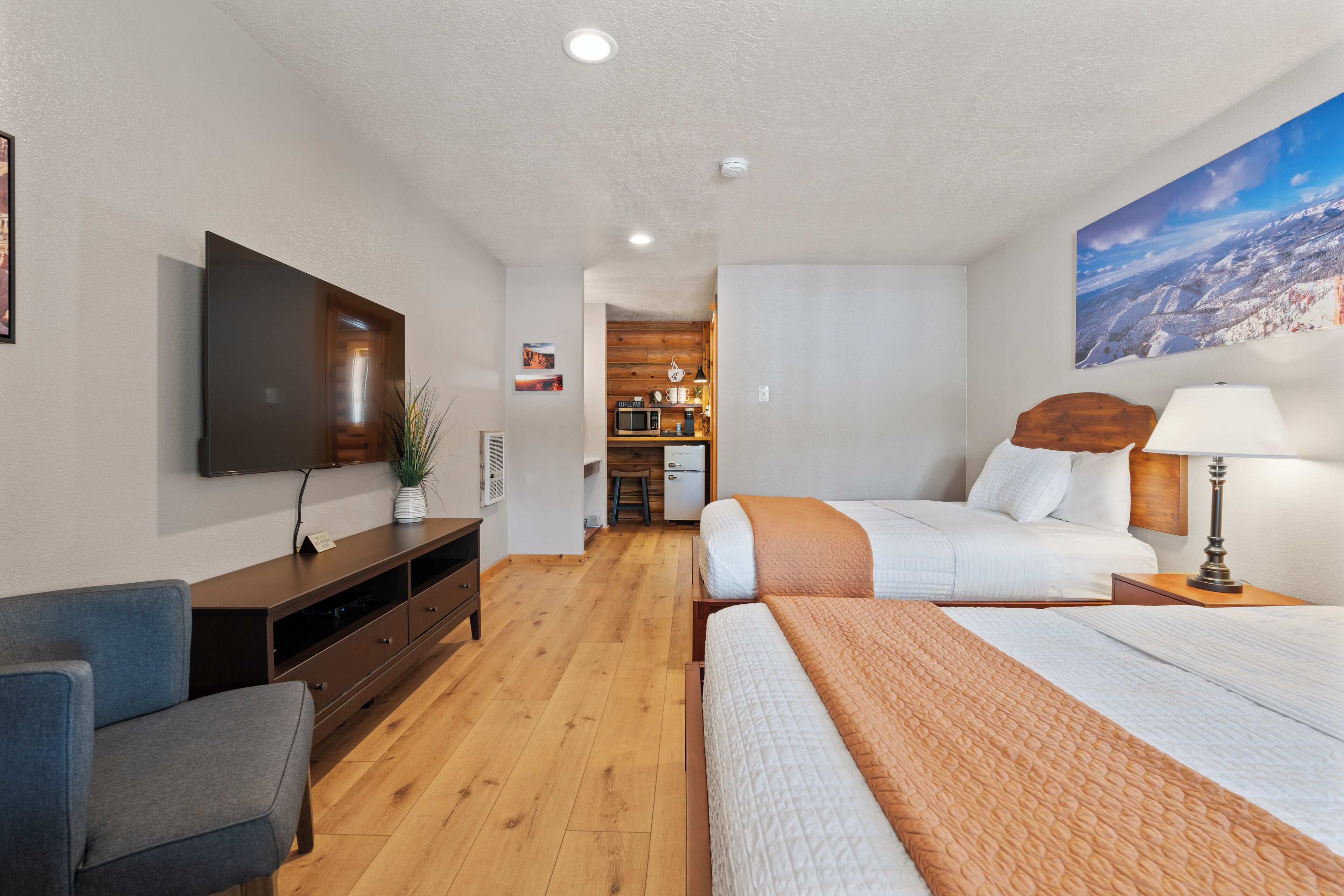 A hotel room with a bed, a TV, a desk, and a chair.
