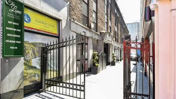 A street view with a boutique hotel entrance, a sign for a hair salon, and a push-up gym.