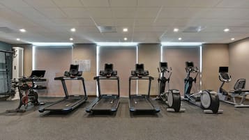 Una palestra con tapis roulant, ellittiche e cyclette.