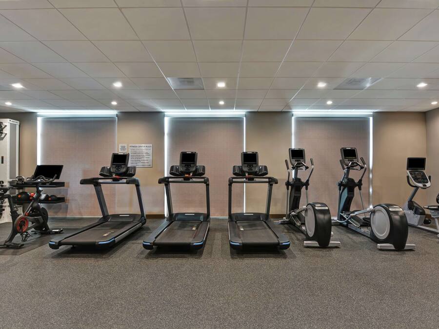 Una palestra con tapis roulant, ellittiche e cyclette.