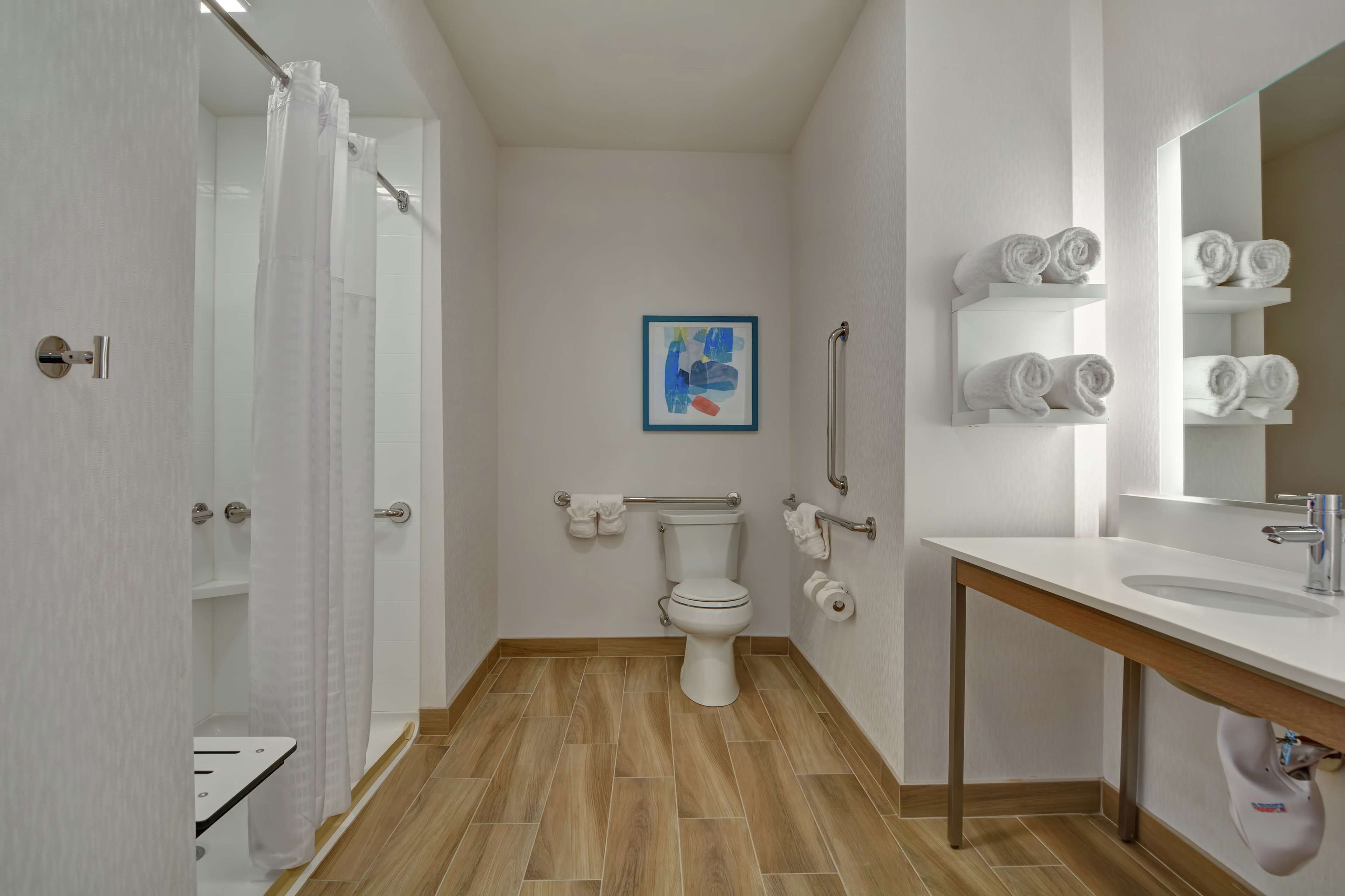 A modern bathroom with a toilet, shower, and sink.
