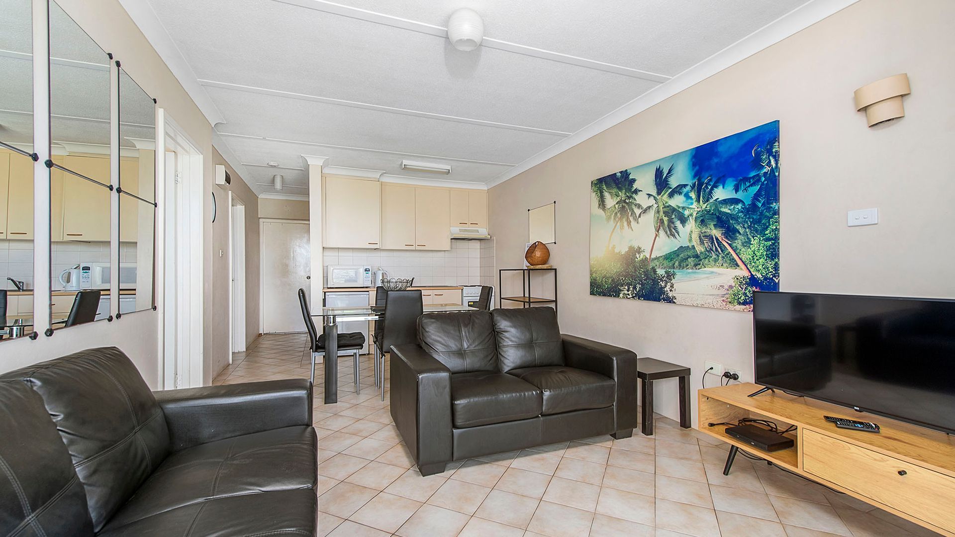 A living room with a sofa, TV, and artwork.