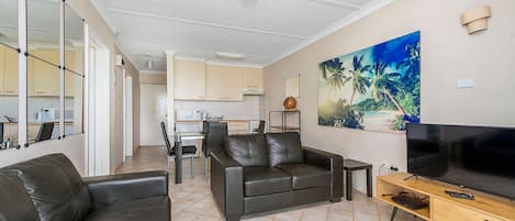 A living room with a sofa, TV, and artwork.