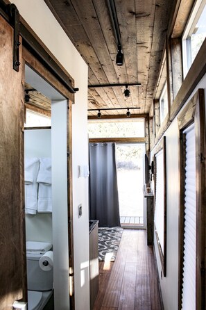 Enter a cozy hallway leading to a bathroom with a toilet and towel.