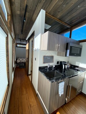 Enjoy cooking in this well-lit kitchen with a granite countertop, stainless steel appliances, and microwave and coffee maker.