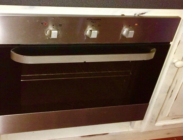 An oven with three control knobs and a digital display.