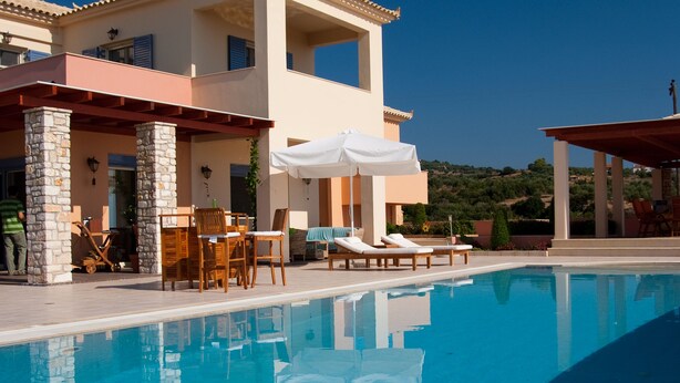 A two-story building with a pool, outdoor seating, and a view of the landscape. - luxury villa,Mesinnia,penthouse sea view, family,reunions,swimming pool,leisure  (Messini)