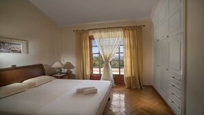 A hotel room with a large bed, two bedside lamps, a window with curtains, and a wardrobe. - Villa Corina near the Athens airport (Attica)