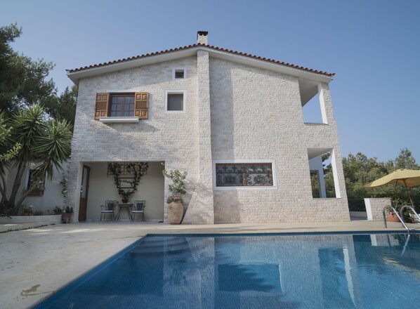Una casa de dues plantes amb una piscina al davant.