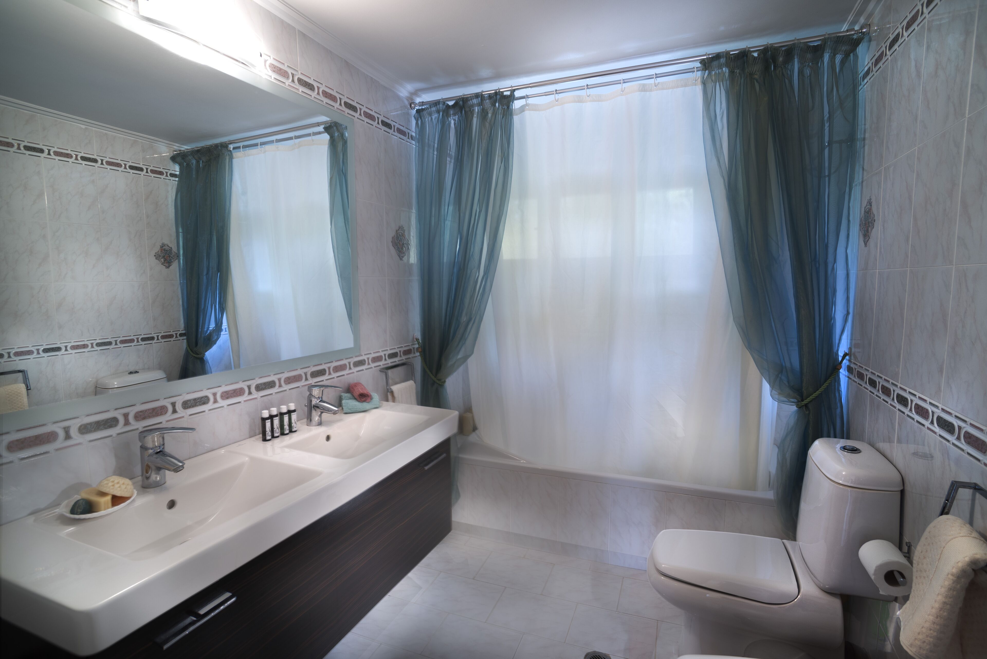 A modern bathroom with a large sink, mirror, and toilet.