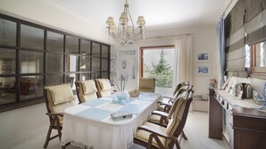 A dining area with a large table, chairs, and a chandelier. - Villa Corina near the Athens airport (Attica)