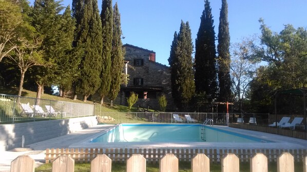 A stone building with a pool, surrounded by trees and a fence with lounge chairs. - Villa park pool exclusively vacation private parties groups up to 35 seats (sansepolcro (arezzo))