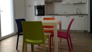 Une cuisine moderne avec des armoires blanches, un four encastré et un évier en acier inoxydable.