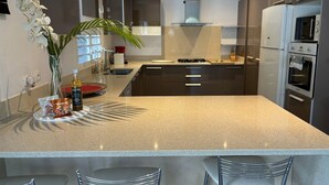 Een moderne keuken met een groot eiland, roestvrijstalen apparatuur en een minimalistisch design.