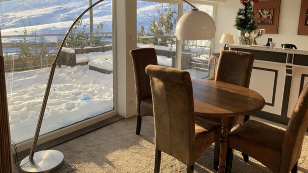 A cozy dining area with a large window overlooking a snowy landscape. - La Traverse, a large family home halfway between Gérardmer and La Bresse. (La Bresse)