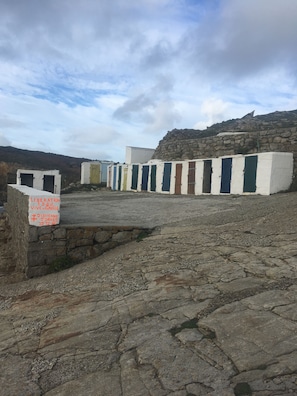 A stone pathway leading to a row of colorful doors, with a sign indicating historical significance.