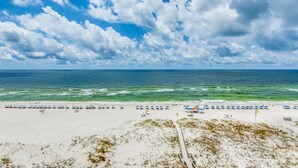A beach with a sandy shore, a clear sky, and the ocean in the background. - Gulf Views! (Pensacola)