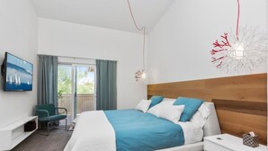 A modern bedroom with a large bed, a TV on the wall, a desk, and a balcony. - ★Modern Ritz Pointe Beach Escape★ STR 23-0009 (Dana Point)
