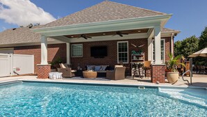 A poolside area with a covered patio, outdoor seating, and a brick house. - Beautiful 4 BR, 4.5 Bath, Executive Home w In Ground Pool & Handicap Accessible! (Louisville)