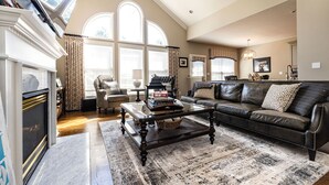 A spacious living room with a fireplace, leather sofa, and a coffee table. - Beautiful 4 BR, 4.5 Bath, Executive Home w In Ground Pool & Handicap Accessible! (Louisville)