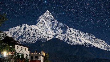A snow-covered mountain under a starry night sky.