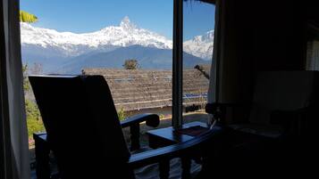 A room with a view of snow-capped mountains through a window.