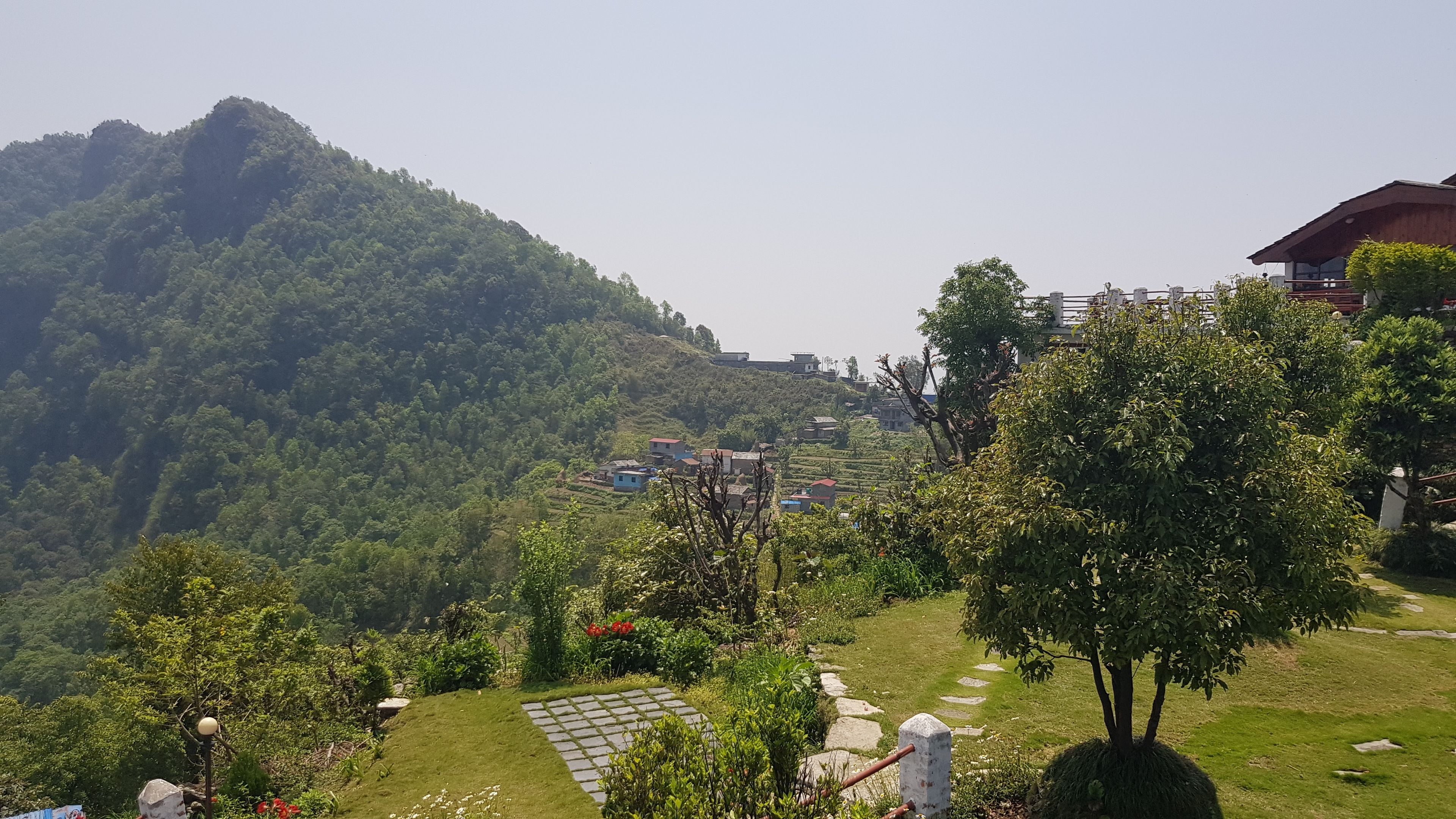 A mountainous landscape with a village and a pathway leading to a building.
