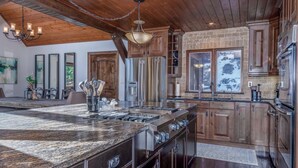 A spacious kitchen with a large island, stainless steel appliances, and wooden cabinetry.