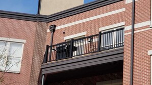 Een tweelaags bakstenen gebouw met een balkon op de tweede verdieping.