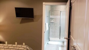 Een badkamer met een douche, toilet en wastafel.