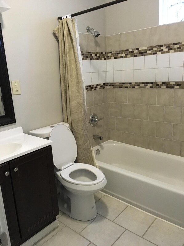 A bathroom with a toilet, a bathtub, and a shower. - The Legacy House - Your Home Away From Home (Columbus)