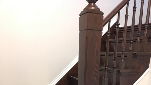 Un escalier en bois, doté d’une rampe et de balustres, menant à l’étage supérieur.