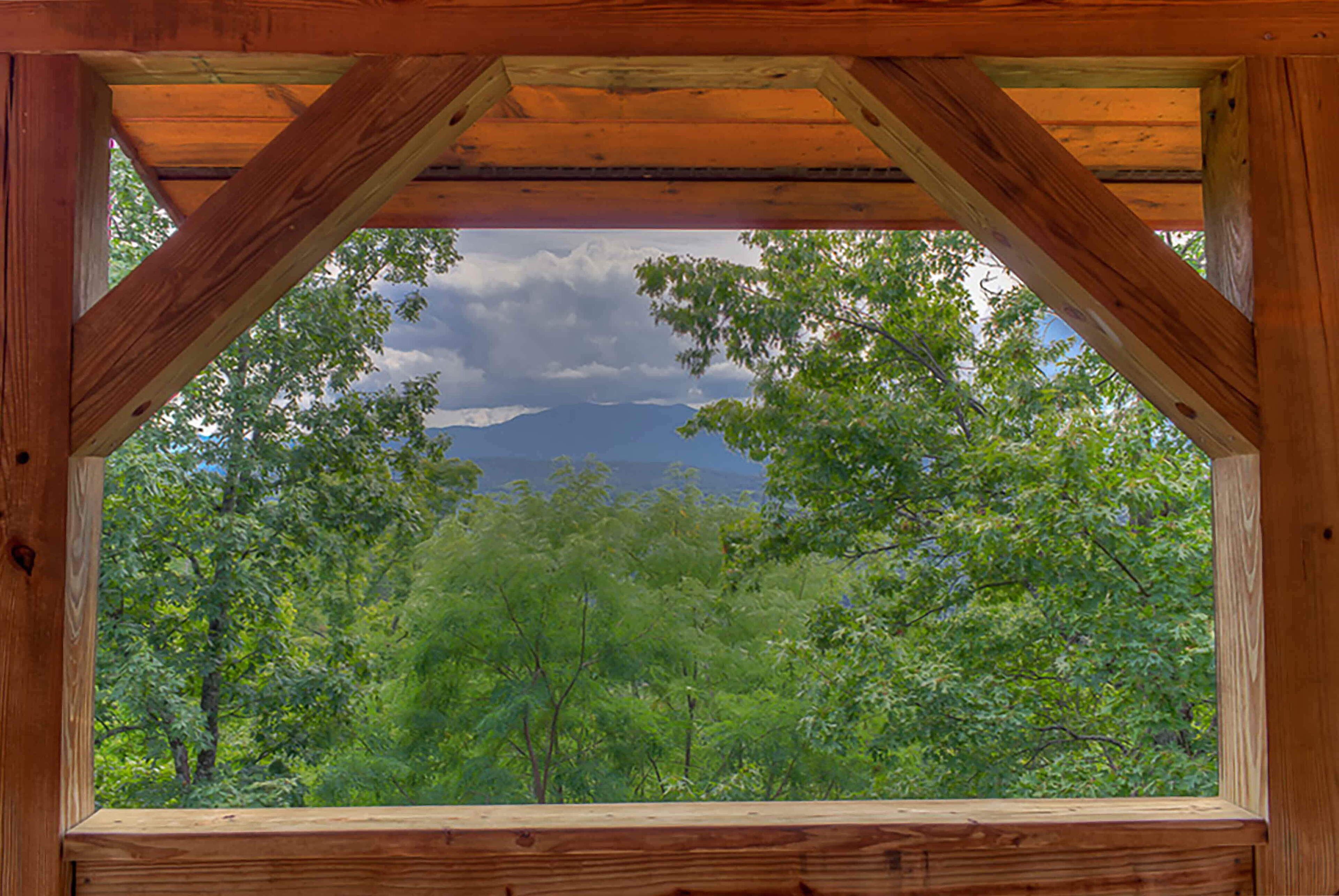 Una struttura in legno con vista su una foresta e montagne.