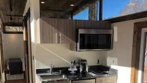 Een moderne keuken met roestvrijstalen apparatuur, houten kasten en een groot raam dat voor natuurlijk licht zorgt.