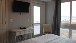 A hotel room with a bed, a desk, a television, and a window with a view of the sea. - Magnificent Bay View!!! Luxurious Condo, Your Home-Away-From-Home, Makai #316 (Ocean City)