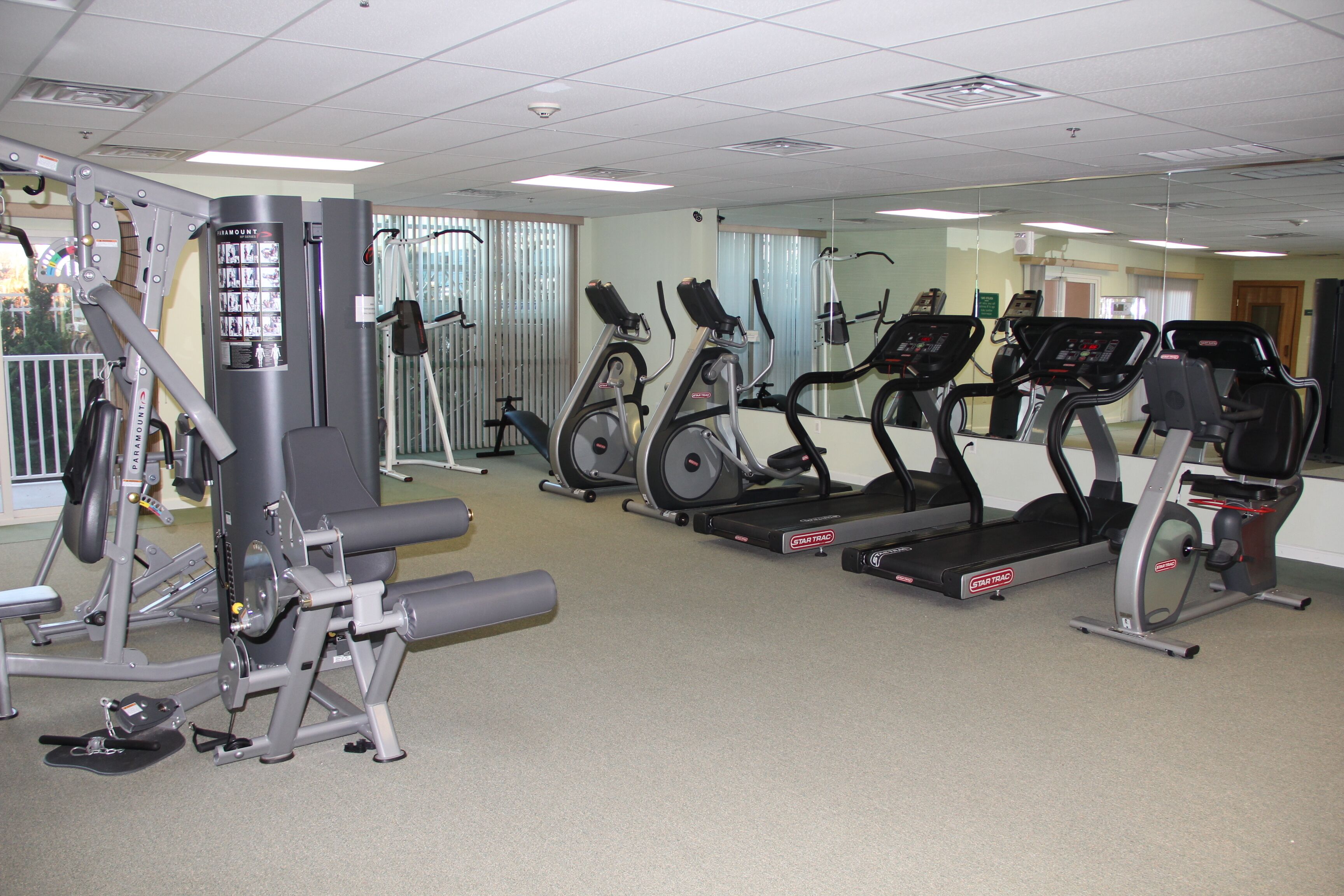 A gym with various exercise equipment including treadmills, stationary bikes, and weight machines.