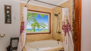 A bathroom with a large bathtub, a window with a view, and a shower area. - 🐻Awesome View: Mtn Views! Secluded, Hot Tub, WiFi, Near Attractions!🗻 (Sevierville)