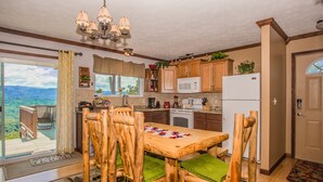 A kitchen with wooden chairs and a table, a microwave, and a refrigerator. - 🐻Awesome View: Mtn Views! Secluded, Hot Tub, WiFi, Near Attractions!🗻 (Sevierville)