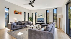 Relax in this stylish living room with a large sofa, coffee table, and flat-screen TV.