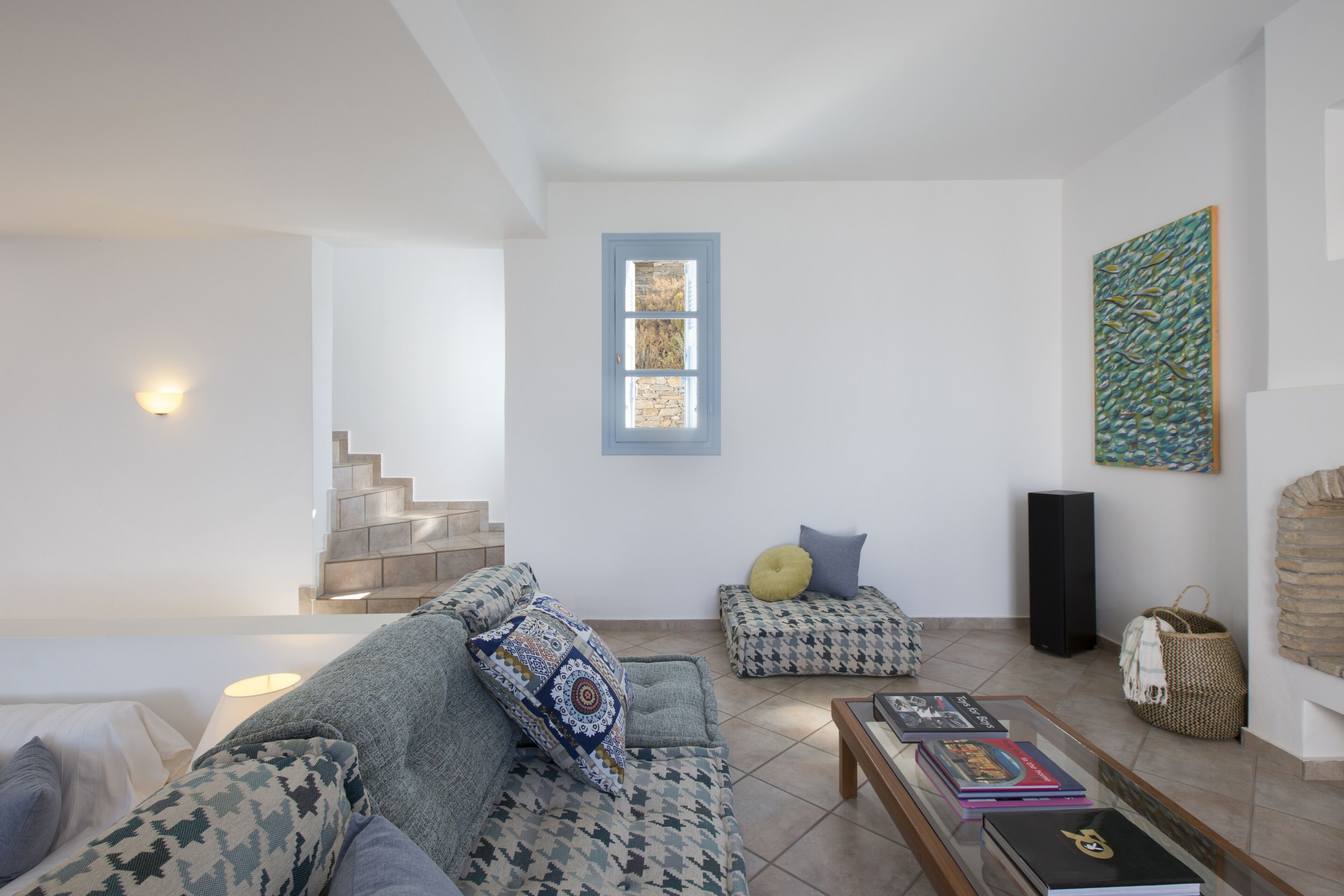 Un salon moderne avec un canapé, une table basse et un escalier.