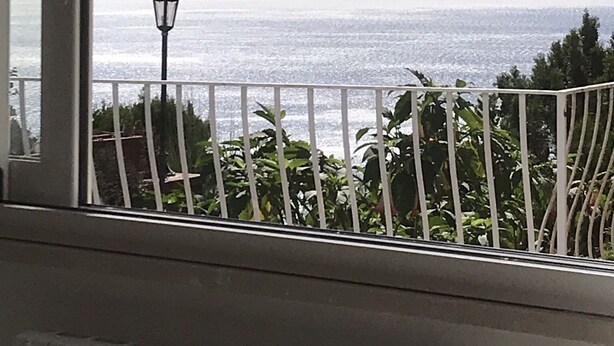 A balcony with a view of the sea, a street lamp, and greenery. - Villa Asia, Holiday home (Massa Lubrense)