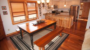A kitchen with wooden cabinets, a central island, and a chandelier. - Three Bears in the Valley (Davis)