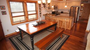 A spacious kitchen with wooden countertops, a central island with stools, and a built-in oven. - Three Bears in the Valley (Davis)