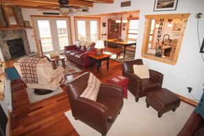Una sala de estar acogedora con sofás de cuero, una chimenea y un comedor con mesa y sillas de madera.